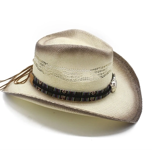 Détail d'un chapeau de cowboy en paille tissée avec bande ethnique et boucles en métal