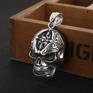 Macro detail of silver skull pendant with intricate engravings and vintage metal texture