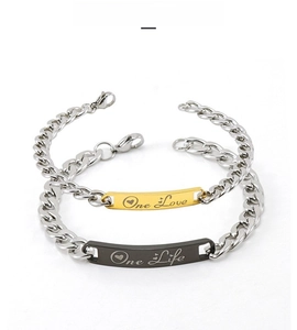 Détail de bracelets de couple en acier inoxydable avec gravure One Love One Life et fermoir