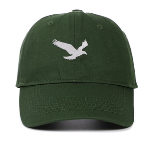 Détail macro d'une casquette vert foncé avec broderie d'aigle blanc en coton de qualité