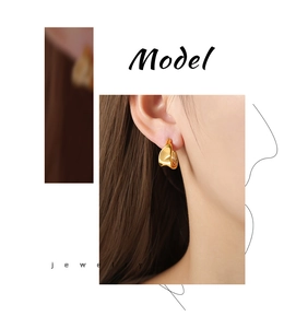 Macro shot of irregular geometric gold plated earrings worn by a model in close-up