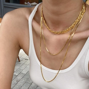 Set di collane a strati con catena a serpente e treccia dorata indossato da una modella
