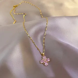 Detail of four-leaf clover necklace with pink pear-shaped crystals on purple satin
