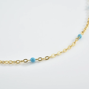 Macro shot of S925 silver gold-plated bracelet with turquoise beads and oval link chain
