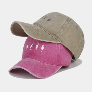 Detail of washed cotton baseball caps in khaki and rose red with LOVE sign language print