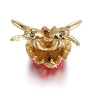 Close-up of golden bunny pendant with red gemstone eyes on a white background