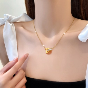 Gold titanium steel D-letter necklace with crystal-embedded ring worn by a model