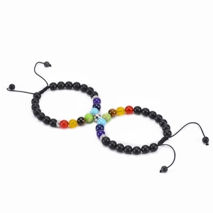 Pair of adjustable tiger eye bead bracelets with matte black and chakra stones on white background