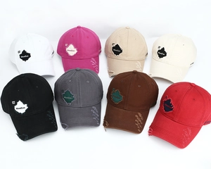 Flat lay of distressed baseball caps in eight colors featuring frayed edges and vintage patches