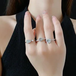 Elegant silver open rings set with heart and flower green stones on model's hand