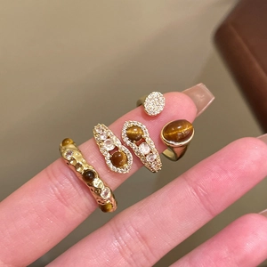 Set of four gold tiger eye and zircon rings for women with vintage wave design