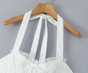 Vue détaillée d'une robe en dentelle blanche avec broderie florale et liens tour de cou