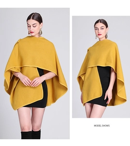 Detail of a thick yellow knitted cape shawl with premium stitching and asymmetric drape cut