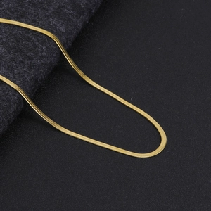Close-up of a minimalist golden flat snake chain necklace with smooth metallic luster