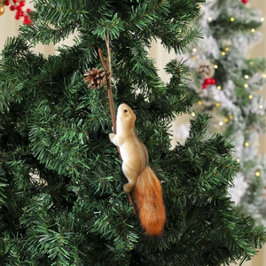 Close-up of a lifelike foam squirrel ornament with a fluffy tail on a Christmas tree