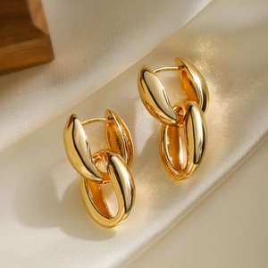 Elegant gold plated double oval interlocking geometric drop earrings on silk background