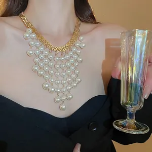 Elegant chunky gold chain necklace with multi-layer pearl tassels on a fashion model