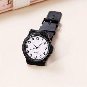 Close-up of a minimalist quartz watch with white dial and black Arabic numerals