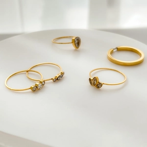 Macro detail of a 5-piece gold ring set with teardrop and marquise zircon accents