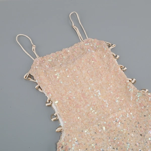 Detail of champagne sequin top featuring thin straps and metallic ring accents