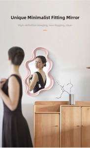 Detail of pink wavy frame irregular decorative mirror for wall mounting or tabletop