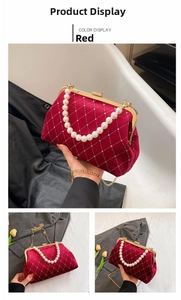 Detail of red velvet shell bag with gold clasp, faux pearls and metal chain strap