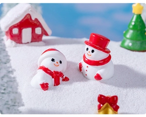 Gros plan de figurines de bonshommes de neige miniatures sur neige pour Noël