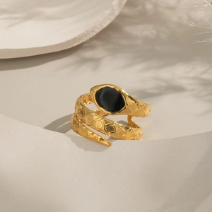 Detail of adjustable gold snake ring featuring black stone inlay and textured scales