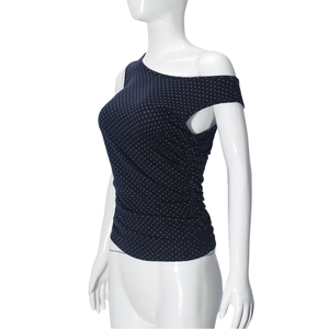 Détail d'un haut asymétrique sans manches bleu marine à pois sur un mannequin blanc