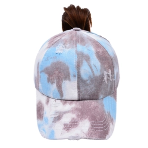 Detail of tie-dye baseball cap featuring messy high ponytail hole and distressed edges