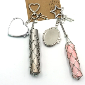 Detail of pink and gunmetal mesh lipstick holder pendant with mirror and bow charm