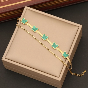 Golden double-layer butterfly necklace with green pendants on a luxury jewelry box