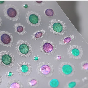 Macro shot of 3D embossed nail stickers featuring holographic colorful gems and gold edges