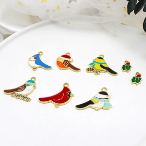 Detail of colorful enamel bird charms with festive Santa hats and green holly leaf pendants