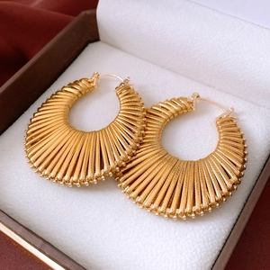 Detail showing vintage gold round hoop earrings with striped texture in a jewelry box
