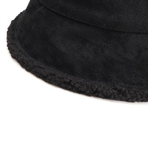 Detail of black suede fisherman hat featuring fuzzy faux shearling brim and premium texture