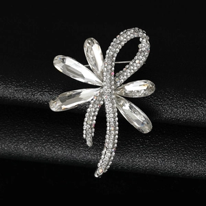 Macro close-up of a silver bow brooch with sparkling marquise and round crystals