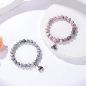 Bracelets de projection en pierre rose et grise avec pendentifs cœur sur socle blanc