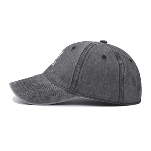 Detail of vintage washed grey cotton baseball cap showing white letter embroidery