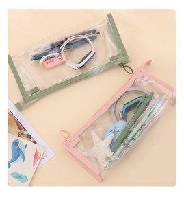 Flat lay of pink and green transparent PVC pencil cases showing storage capacity