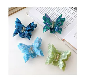 Detailed top view of acetate butterfly hair claws with ink and floral patterns
