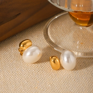 French vintage gold oval pearl earrings on elegant wooden tray and glass setting