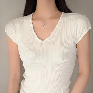 Minimalist knot pendant gold necklace on model wearing white V-neck knitted sweater