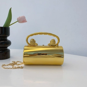 Detail of gold mirror acrylic evening bag with lion head handle and metal chain