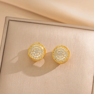 Elegante goldene runde Ohrstecker mit weißen Zirkonia auf einer beigen Schmuckschatulle