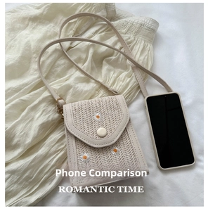 Detail of straw woven phone bag with daisy embroidery and magnetic flap closure