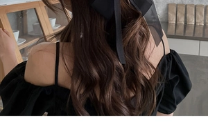 Close-up of a large black mesh bow hair clip used for a half-up elegant hairstyle