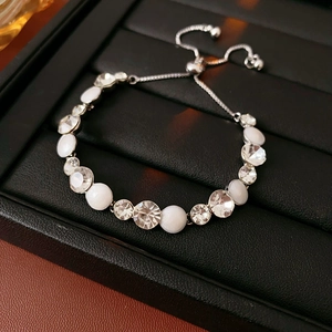 Détail du bracelet réglable en argent avec perles blanches et cristaux sur cuir noir