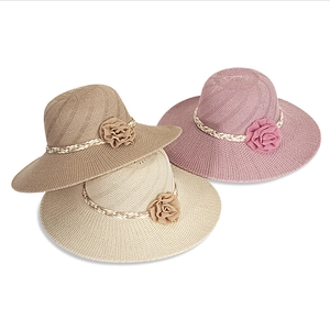 Detailed texture of wide-brim straw hats with decorative floral accents in three colors