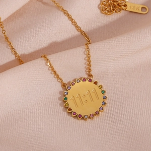 Detail of 11:11 pendant necklace with colorful zirconia on gold silk background